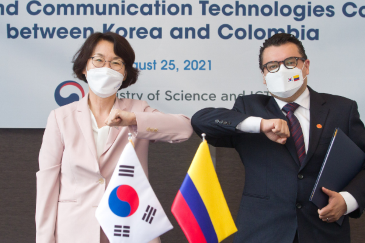 Foto de una hombre y una mujer con las banderas de Colombia y Corea