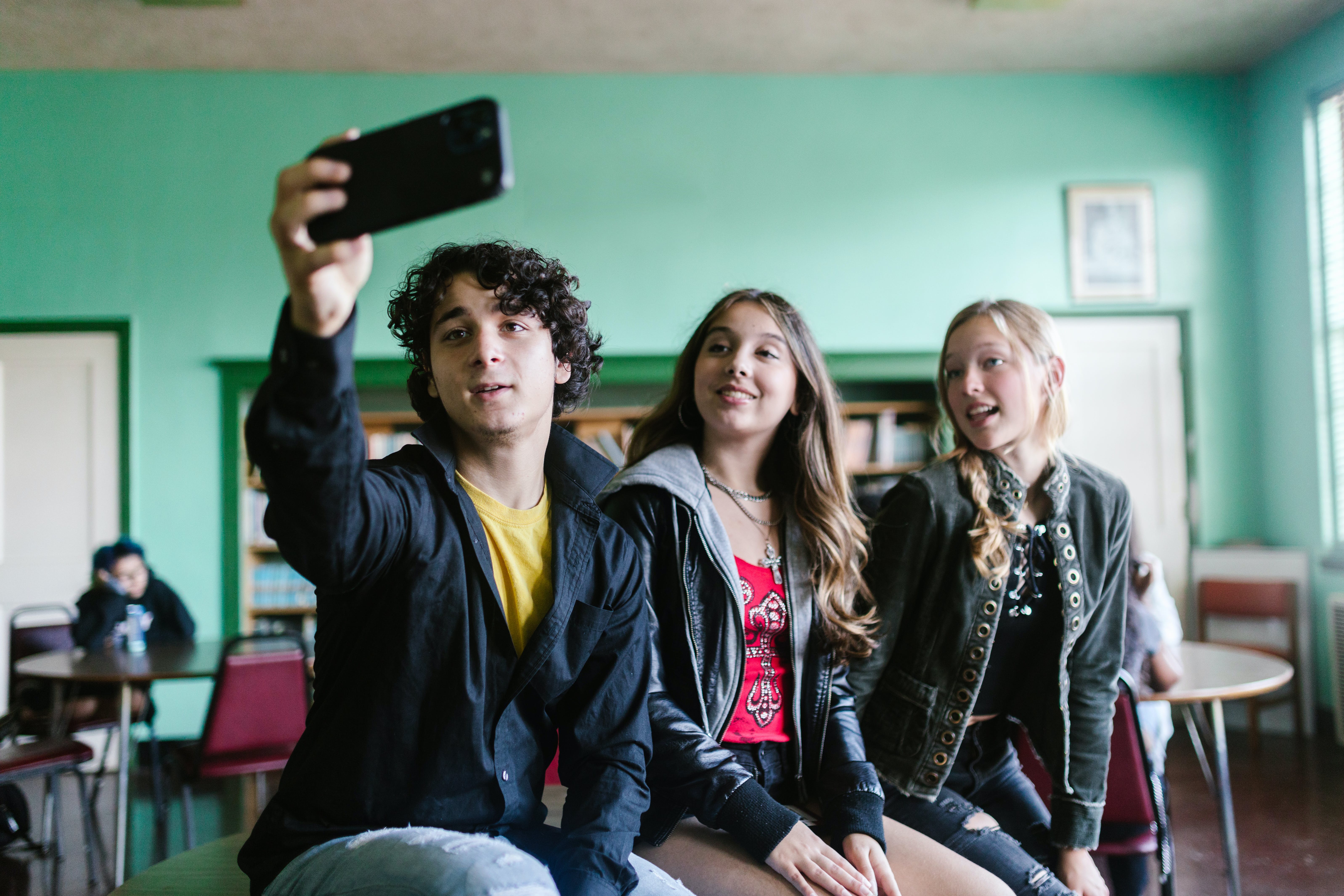 Un estudiante tomando un selfie junto a dos compañeras