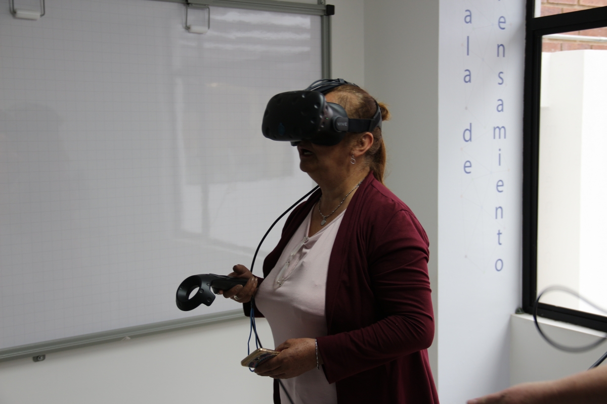 Fotografía de una maestra viendo por unas gafas de realidad virtual