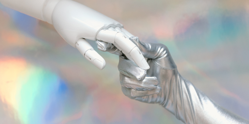Una mano humana tomando otra mano de robot