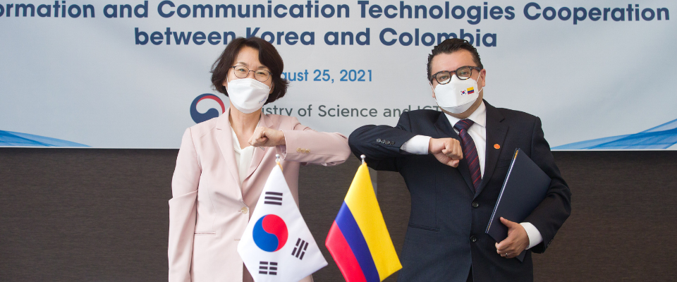 Un hombre y una mujer de Colombia y Corea chocando los codos