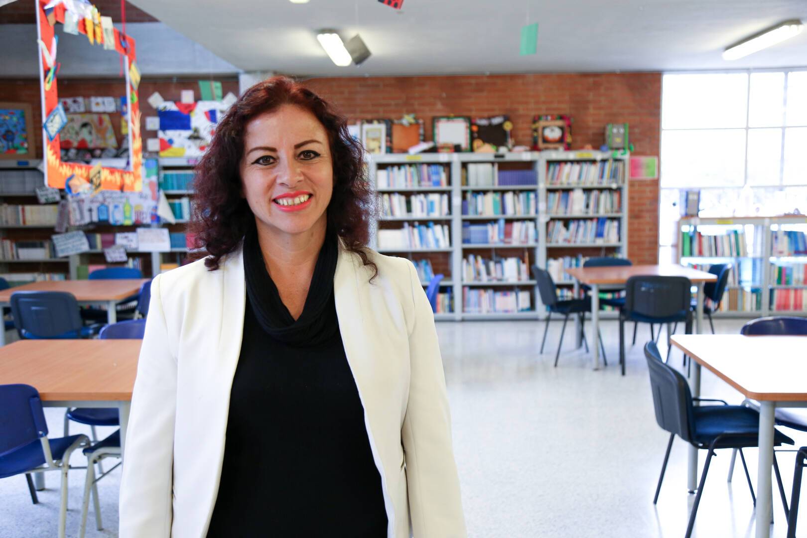 Foto de profesora en una biblioteca sonriendo