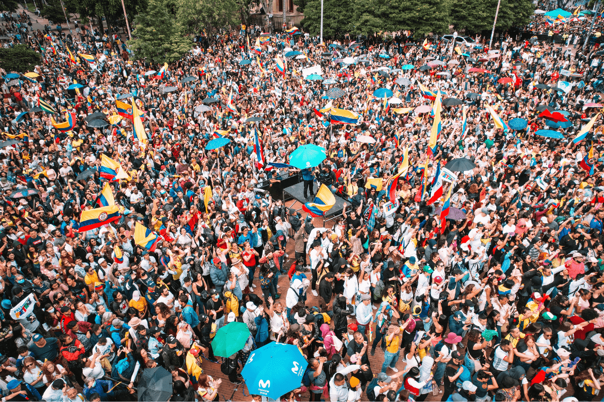 Foto de cientos de personas reunidas en la calle con banderas de Colombia