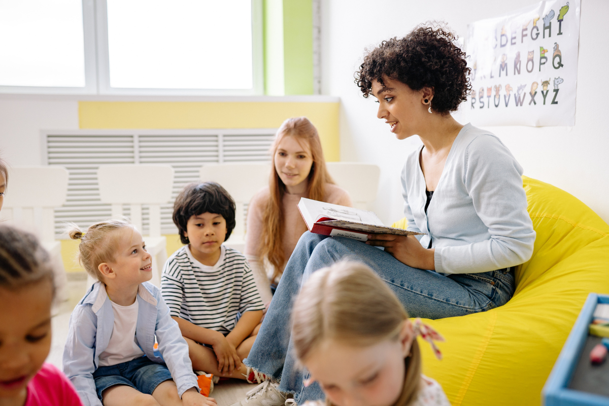 Foto de una Maestra leyendo para estudiantes de edad entre 5 y 6 años