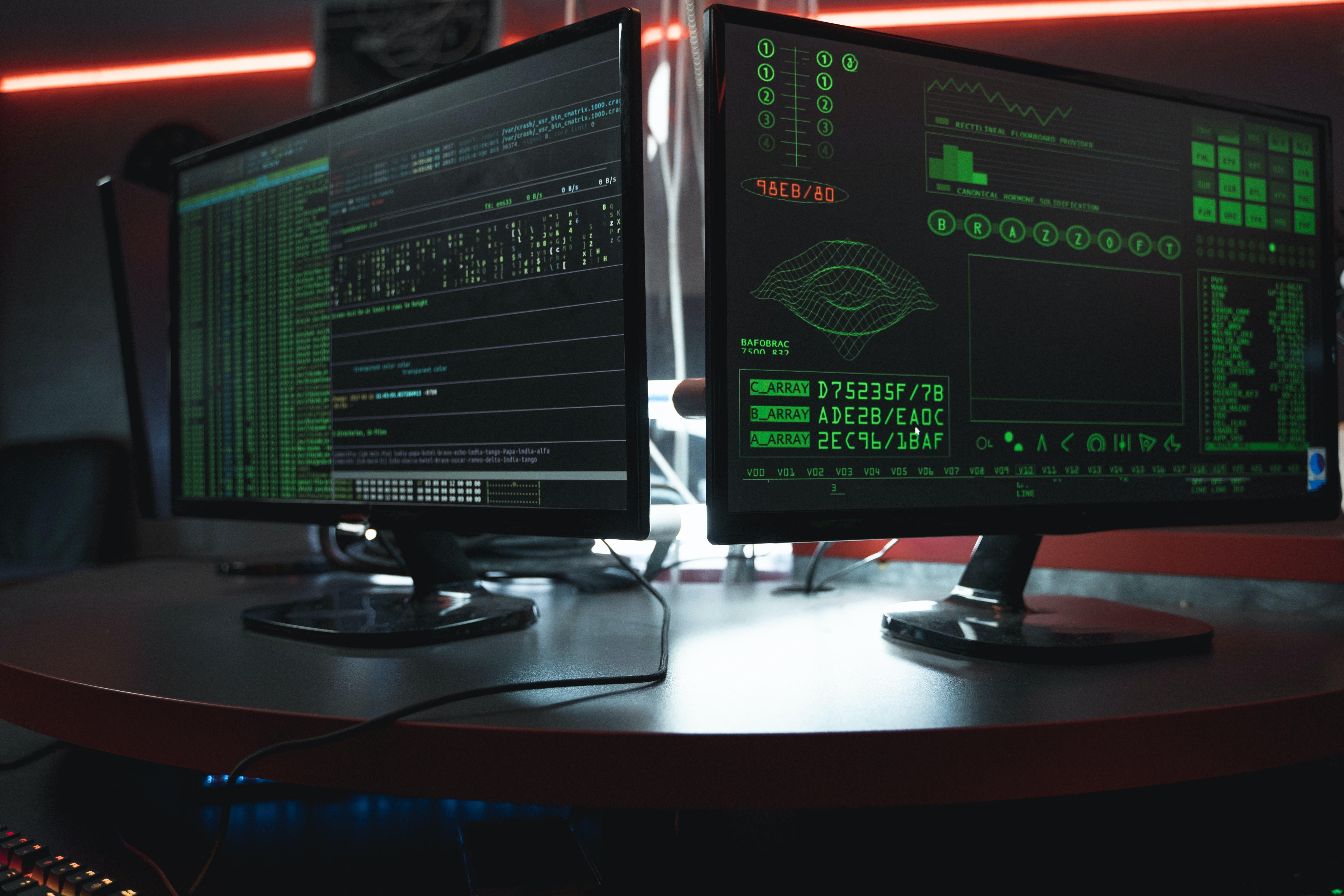 Imagen de dos monitores de computador con códigos de programación