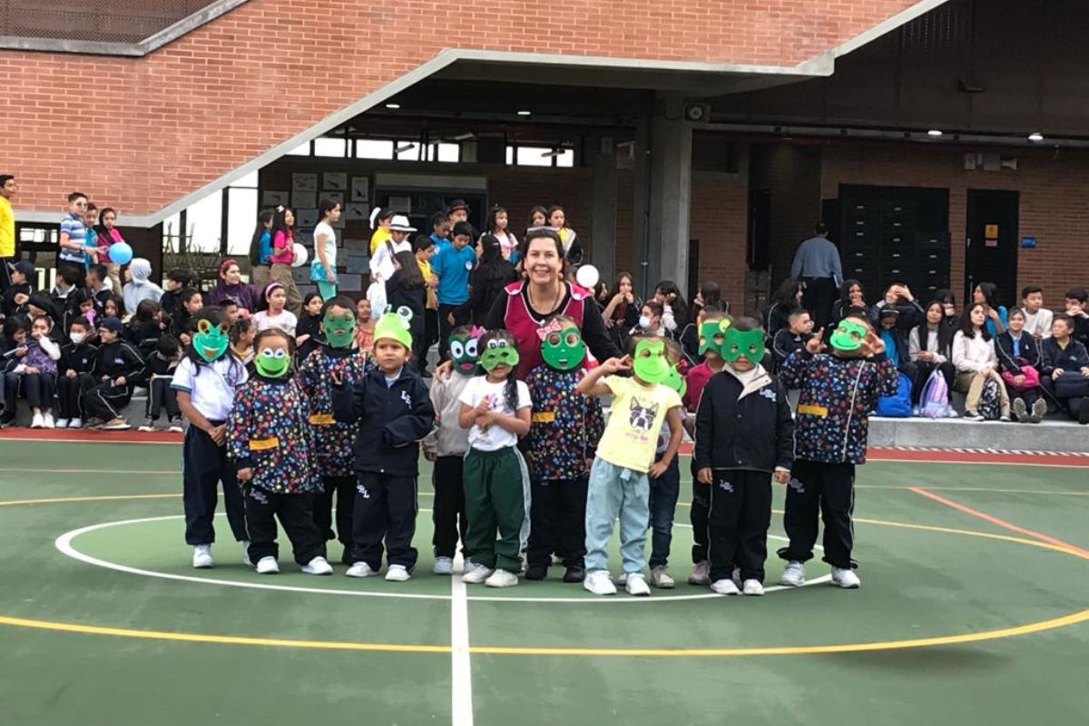 Maestra Astrid Martínez junto a varios de sus estudiantes