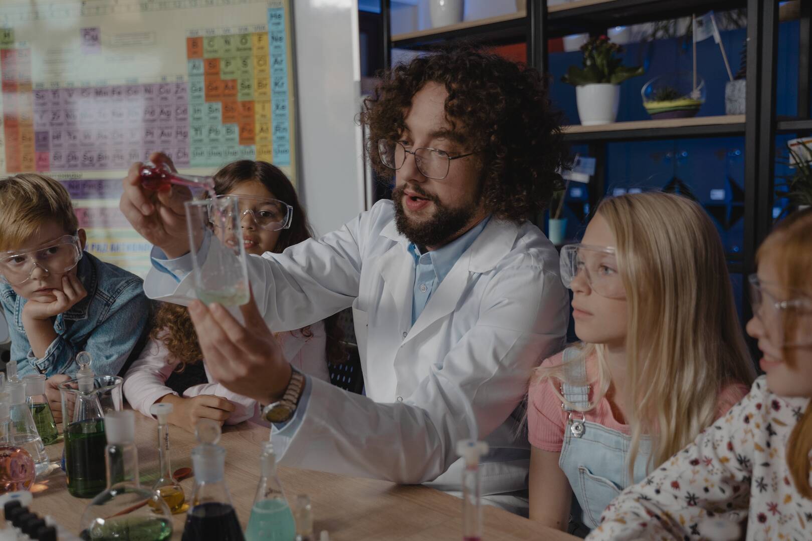 Un Maestro haciendo practicas de laboratorio con varios estudiantes