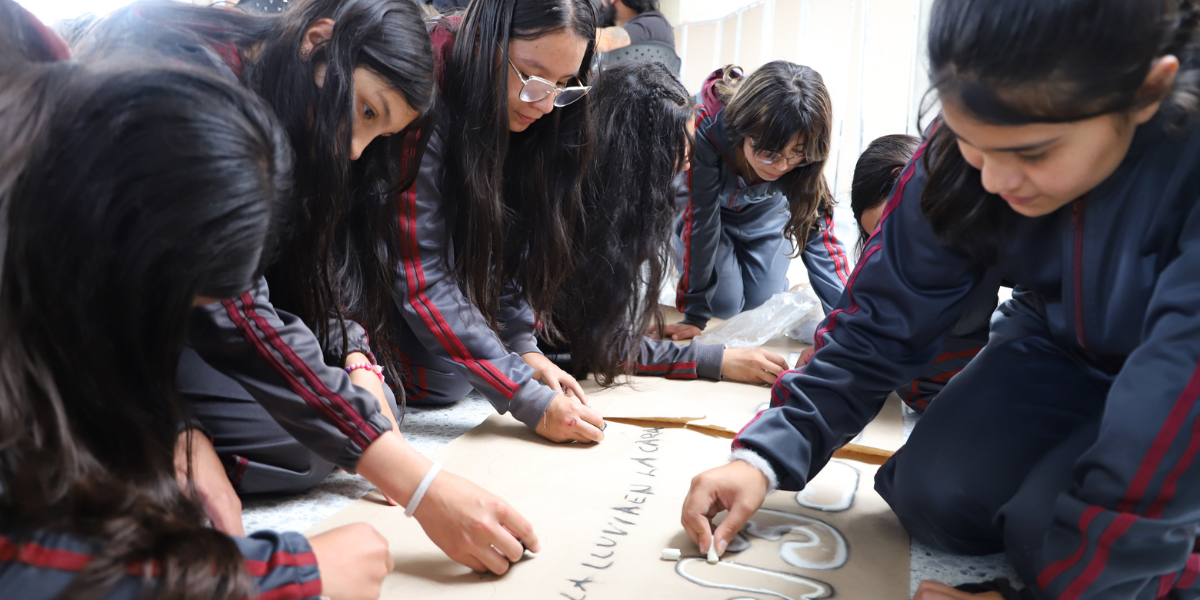 Estudiantes pintando una pancarta