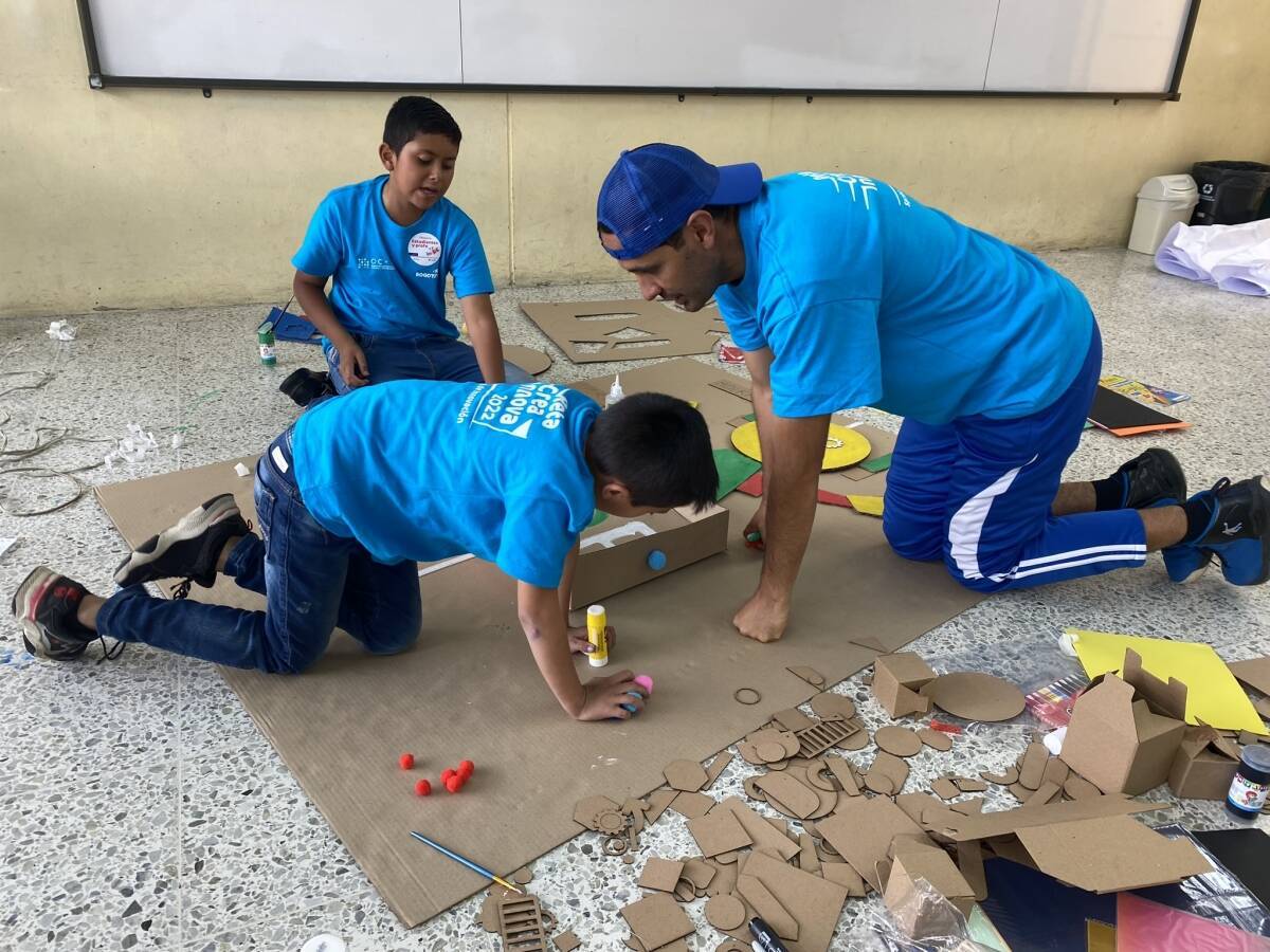 Fotografía de un profe con dos alumnos participantes