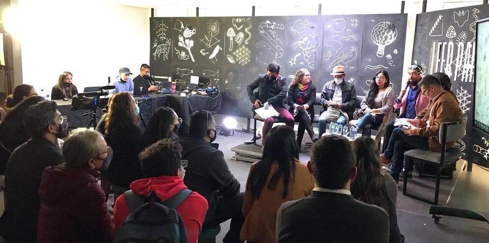Fotografía de varios profes como expositores ante varios participantes en un salón de conferencias 