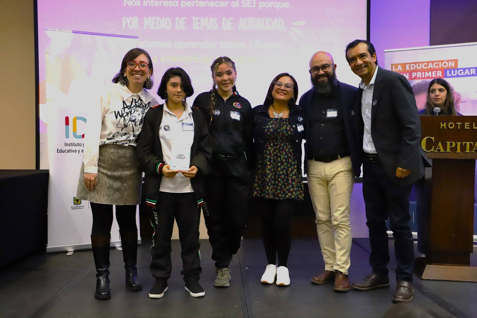 Foto de tres docentes con el Director del Idep y dos estudiantes mujeres