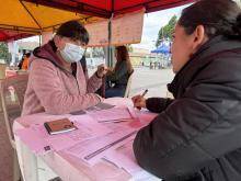 Funcionaria del IDEP explicando a una ciudadana en unos formatos